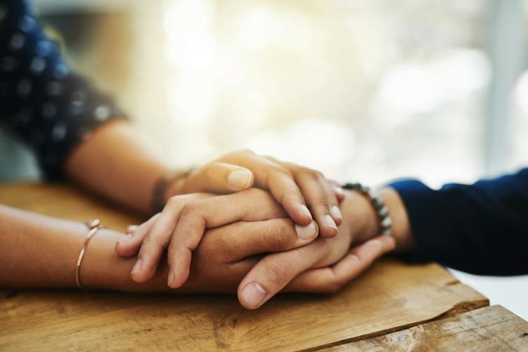 Une personne tenant la main d’une autre personne pour la consoler
