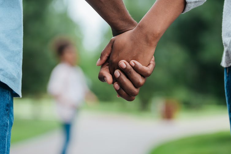Couple dans le parc se tenant les mains.