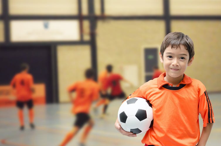Un jeune enfant tenant un ballon de football.