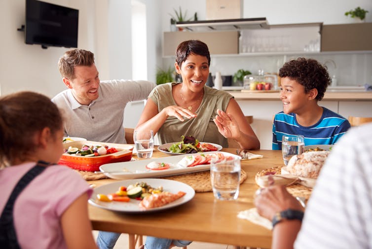 Mère parle à sa famille à table