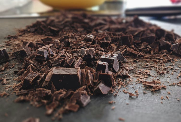 Chocolat noir haché sur une planche.