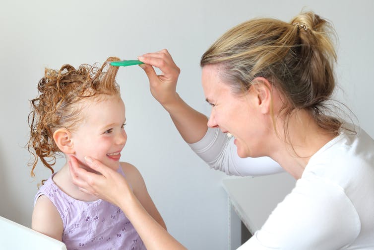 Maman peigne les cheveux de l'enfant