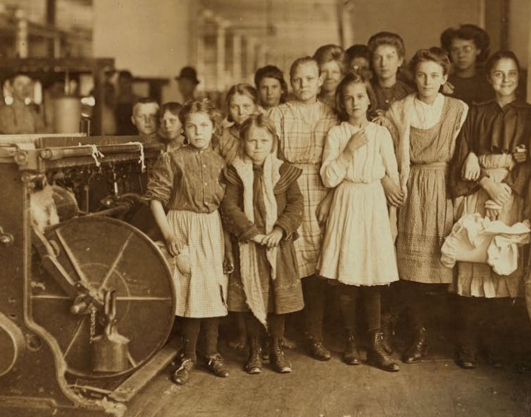 Un groupe de filles et d'adolescents posent à côté d'un gin de coton.