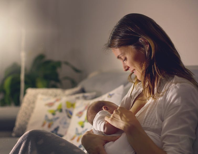 Une femme regarde son bébé pendant l'allaitement.