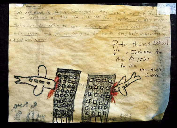 Une note d'enfant exprimant sa tristesse pour les victimes des attentats terroristes du 11 septembre, accompagnée d'un dessin de deux avions s'écrasant contre deux tours.