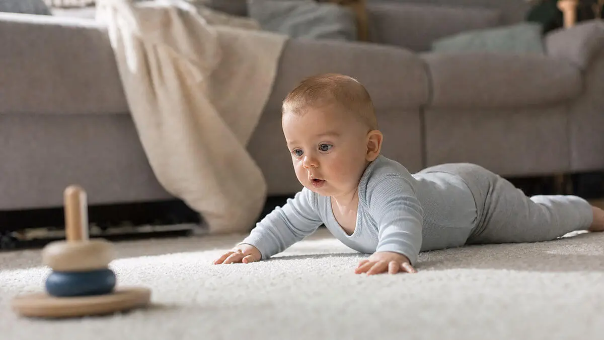 Bébé couché dans un berceau avec une famille à proximité floue, environnement clinique à domicile, brève pause avec expression attentive, cadrage