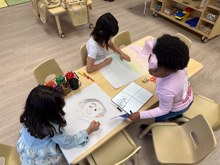 Trois filles dessinent autour d'une table au Children's Promise Center d'Albuquerque, au Nouveau-Mexique.